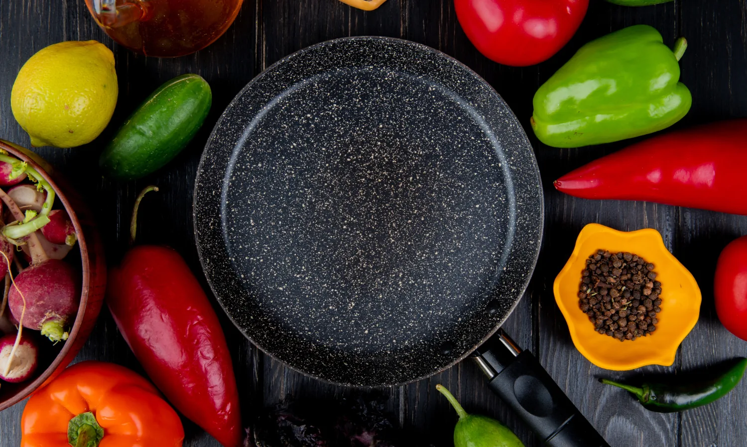 Granite-finish TIFLI pan surrounded by fresh vegetables