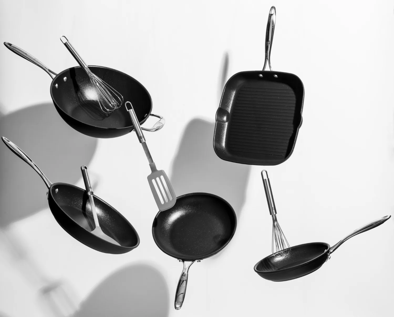 TIFLI pans and kitchen utensils arranged on a white surface